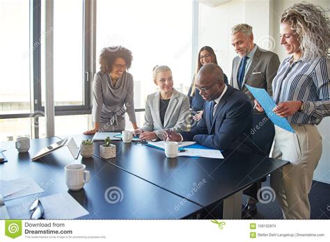 Diverse Group Of Executives Working Together Around A Boardroom Stock