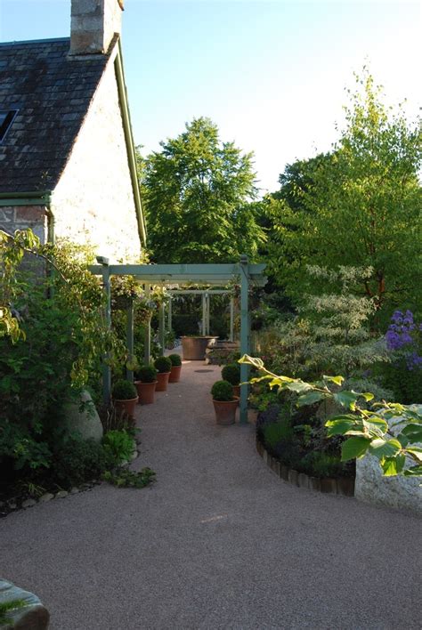 The pink herringbone path that runs through the tiny garden leads to a door, creating a magical effect. Garden Design - Secret Gardens | Aviemore Garden