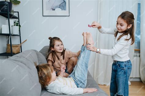 Premium Photo Experimenting Girls Tickling Boys Feet With Feather He