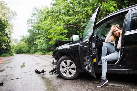 Young Woman In The Damaged Car After A Car Accident Making A Phone