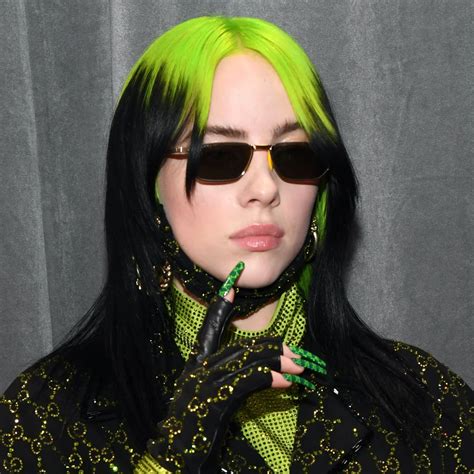 billie eilish with neon green roots and high contrast black length black and green hair neon