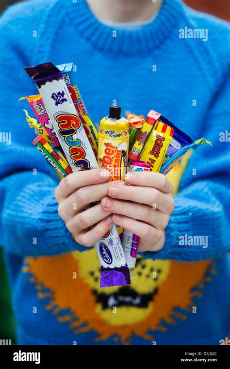 Boys Hands Holding Assorted Childrens Retro Sweets And Candy Stock