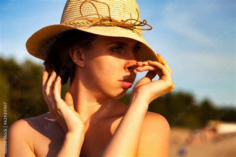 Face Of Naked Woman In Summer Hat Posing On Nudist Sea Beach Looking Away Perfect Nude Lady