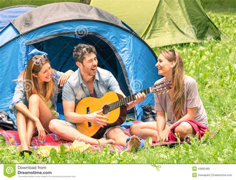 Group Of Best Friends Singing And Having Fun Camping Outdoors Stock