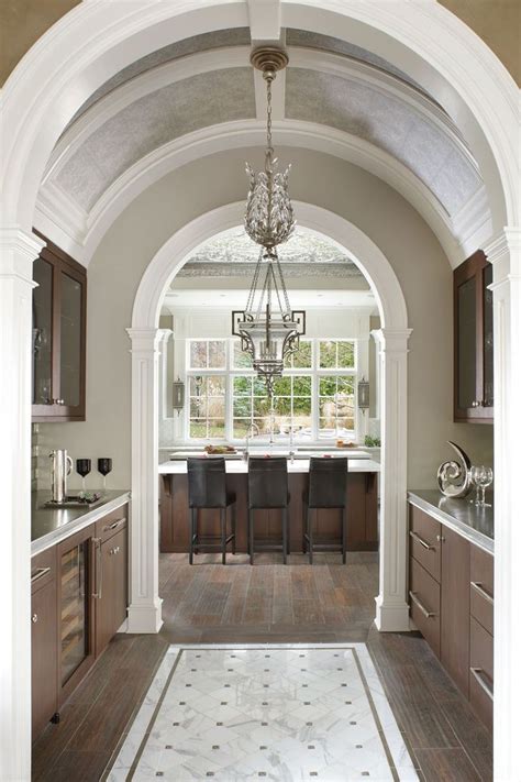An Archway Leading To A Kitchen With Lots Of Counter Space And Cabinets