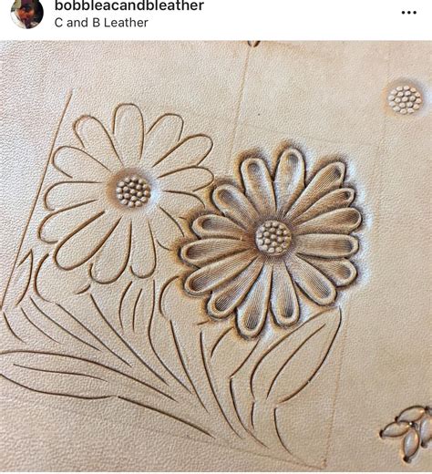 A Close Up Of A Flower Design On A Leather Surface