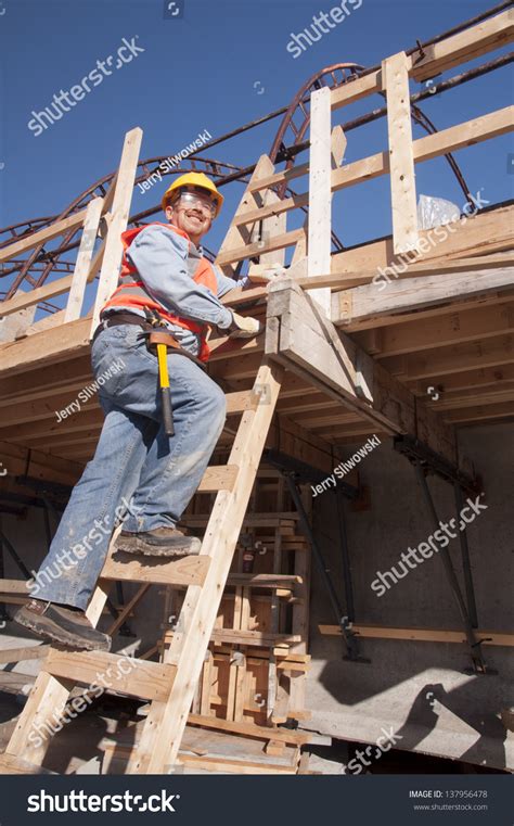 Construction Worker Climbing Ladder At Construction Site Stock Photo