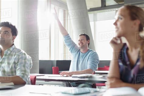 Eager Man Raising Hand In Adult Education Classroom Stock Photo