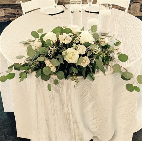 Sweetheart Table Centerpiece With White Flowers And Greenery Simple