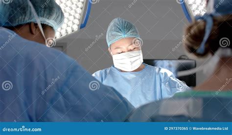 Diverse Female Surgeons Operating On Patient In Operating Theatre Slow