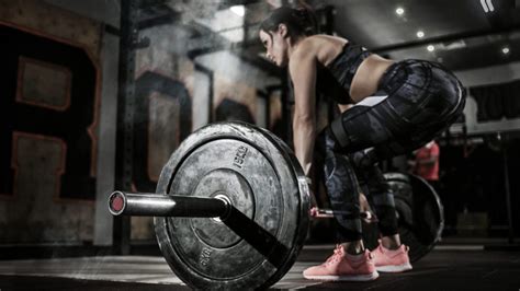 Sport Muscular Women Lifting Deadlift In The Gym With Barbell Dramatic Interior With Smoke