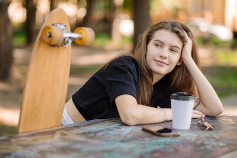 Premium Photo Portrait Of Pretty Teenager Girl With A Skateboard Is Sitting And Resting On The