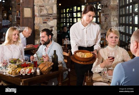 Young Female Waiter Serving Country Restaurant Guests Stock Photo Alamy