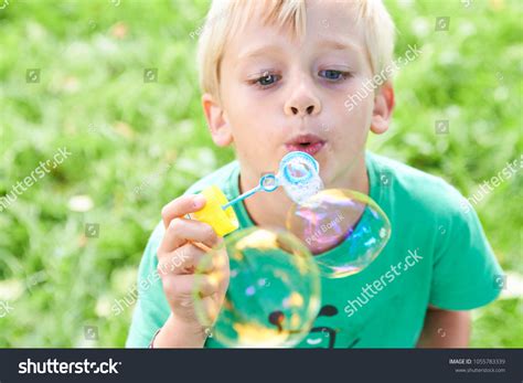 Young Boy Blowing Bubbles Greenery Background Stock Photo 1055783339