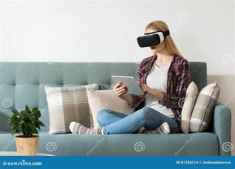 Attractive Woman Wearing Virtual Reality Glasses Sitting On A Couch Vr