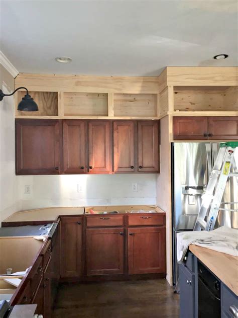 You will likely need a step stool or have to stand on your it may cost less, but having a gap between your uppers and the ceiling can interrupt the flow of your cabinet design. Building Cabinets up to the Ceiling from Thrifty Decor Chick