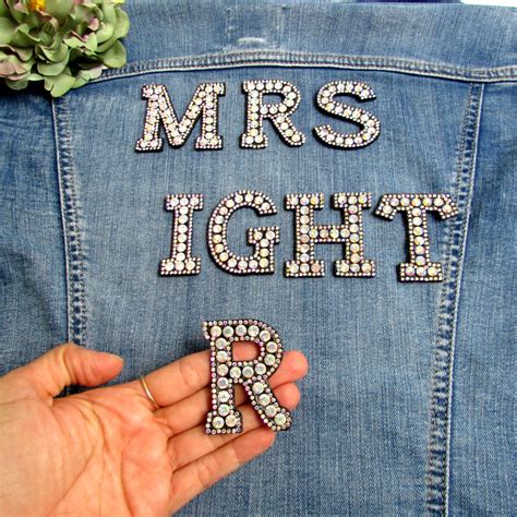 A towel or sheet of blank paper. Black iron-on monogram letters Rhinestone iron-on initials ...