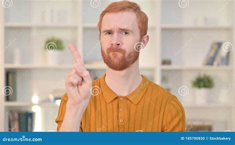 Portrait Of Attractive Redhead Man Saying No By Finger Stock Photo