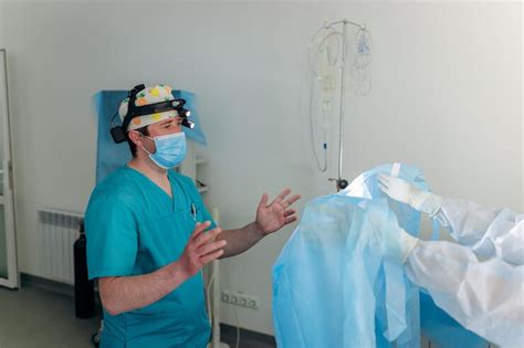 Krankenschwester Bindet Dem Chirurgen Vor Der Operation Ein Steriles Kleid An ärzte Bereiten