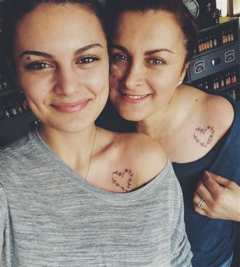 two women with tattoos on their chest posing for the camera