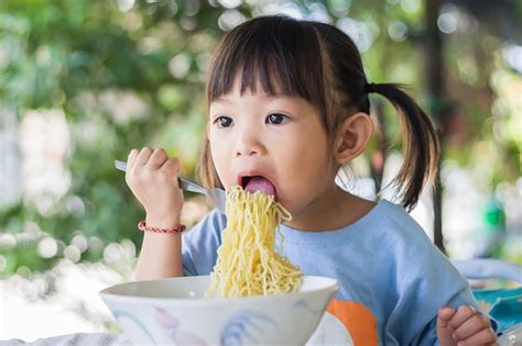 Premium Photo Happy Asian Child Girl Enjoy Eating Some Noodles By