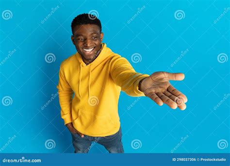 Happy Millennial Black Guy Holding Something On His Palm Stock Photo