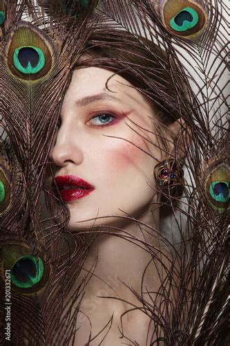 Glamorous Portrait Of Young Beautiful Woman In Peacock Feathers Stock