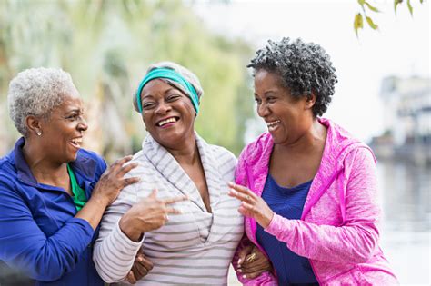 Three Senior Black Women Laughing Together Outdoors Stock Photo
