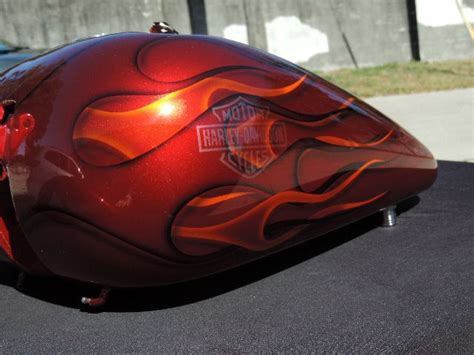 A Red Motorcycle With Flames Painted On Its Face And Side View Mirror