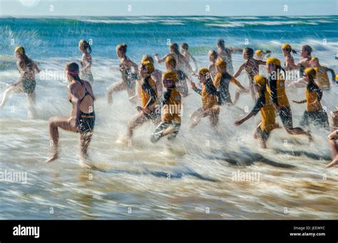 Nippers Running Into The Ocean During Surf Lifesaving Beach Swimming