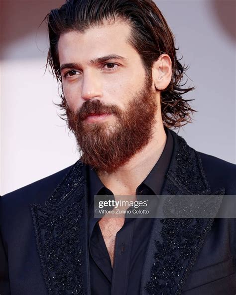 A Bearded Man With Long Hair And Beard Wearing A Black Suit At The