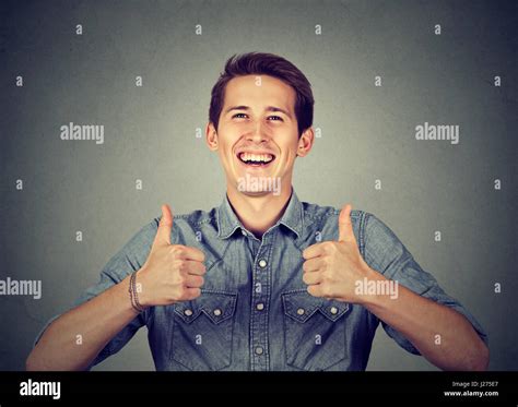 Happy Man Giving Thumbs Up Sign Isolated On Gray Wall Background Stock