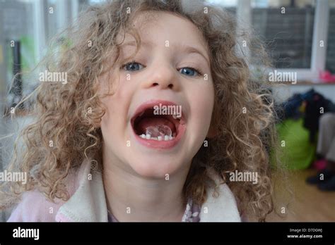 Five Year Old Girl With Curly Hair And Blue Eyes Showing An Ice Cube