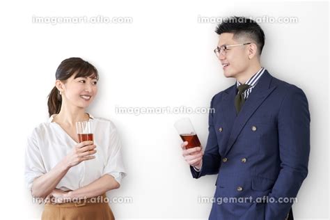 交流会でグラスを持ち、話をするアジア人ビジネスパーソンの写真素材 156831535 イメージマート