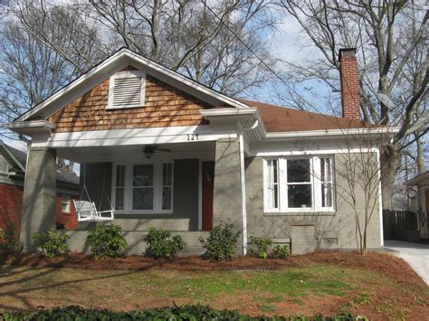 A beautiful large custom bungalow home with a grey brick and stone exterior and a 3 · red brick house behind a wooden fence. Our Urban Bungalow: A Curb Appeal Redo