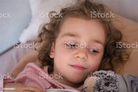 Sick Girl Lying In Bed With A Runny Nose And Fever Caused By A Seasonal