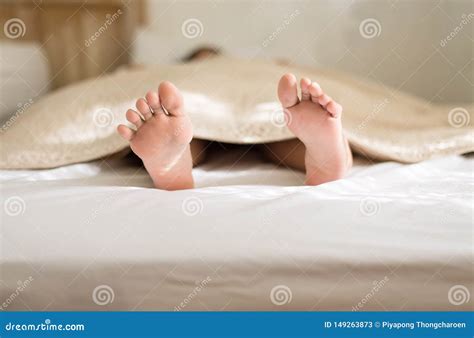 Female Barefoot Or Feet On Bedroom Under Blanket In The Morningclose