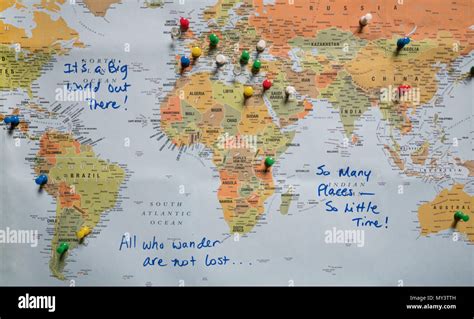 A World Map With Travel Quotes And Countries Identified With Push Pins