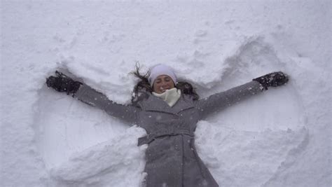 Slow Motion Young Woman Making Snow Angels Stock Footage