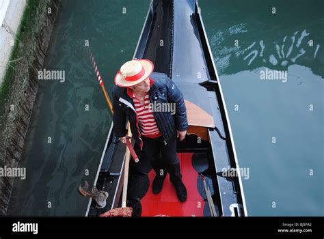 Gondolier Passing Under A Bridge In His Gondola Venice Italy Stock Photo Alamy