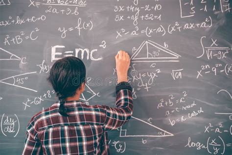 Teacher Or Student Writing On Blackboard During Math Lesson In School