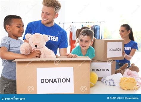 Volunteers With Children Sorting Donation Goods Stock Image Image Of