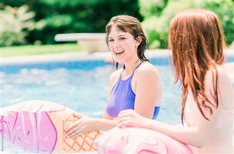 Sisters Play With Floats In A Swimming Pool By Stocksy Contributor