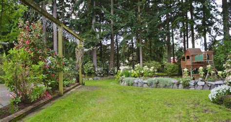 House Spring Backyard With Rock Wall And Kids Playground Stock Photo