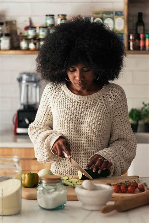 Beautiful Black Woman Cooking In Her Home by Stocksy Contributor Santi Nuñez Stocksy