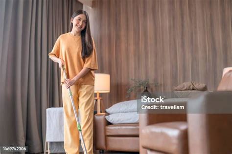 foto de mulher feminina jovem da Ásia que trabalha em sua nova casa ela está limpando o chão com