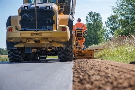 Road Construction Workers Repairing Highway Road On Sunny Summer Day