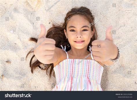 Smiling Cute Little Girl Lying On The Sand Royalty Free Stock Photo
