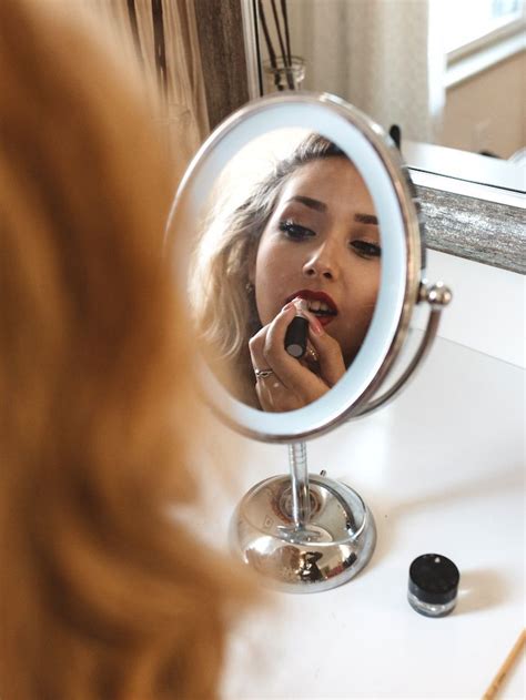 A Woman Brushing Her Teeth In Front Of A Mirror