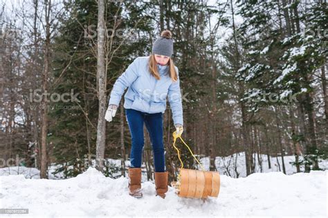 Happysmiling Teen Girl Pulling A Wood Toboggansled To The Edge Of A